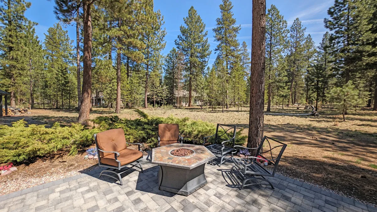 An inviting fire pit area with a circular seating arrangement nestled among tall trees. The setting is perfect for evening gatherings, storytelling, and stargazing, creating memorable moments across generations.